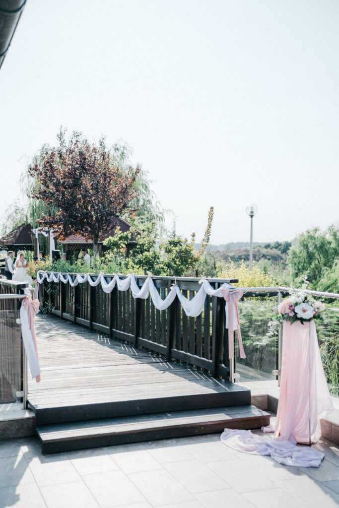 Elegáns esküvői dekoráció a Nádas Pihenőparkban, magas állványokkal, virág dekoráció
