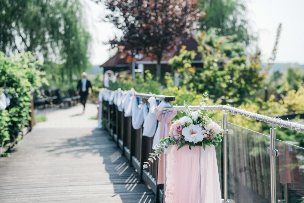 Elegáns esküvői dekoráció a Nádas Pihenőparkban, magas állványokkal, virág dekoráció